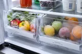 Frozen fruits and vegetables coated in frost inside a fridge freezing everything