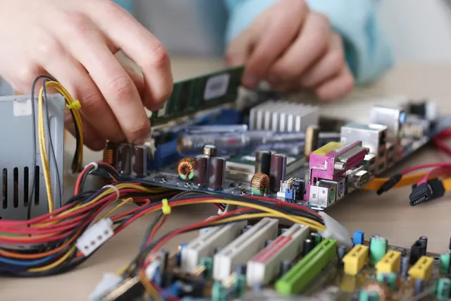 Technician's hands working on the electronic control board of a washing machine that won't start