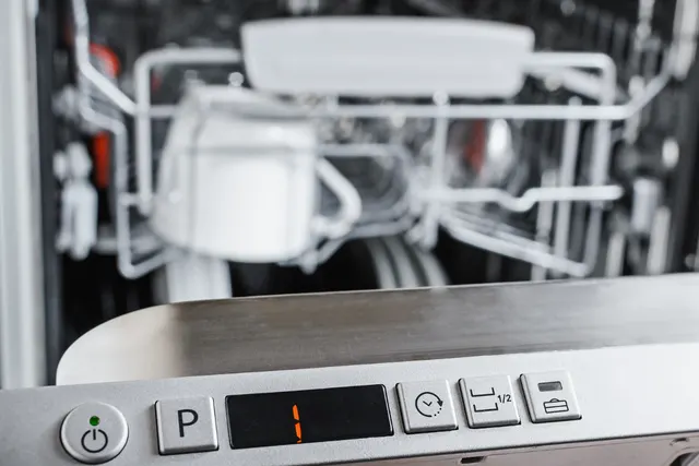Dishwasher control panel showing 1 with dishes on the rack behind it