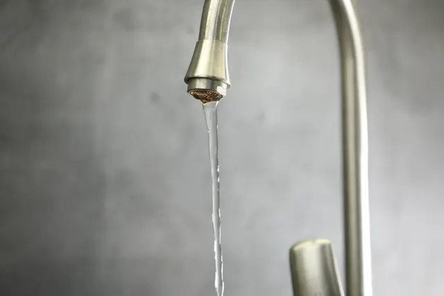 Kitchen faucet running with a narrow stream of water